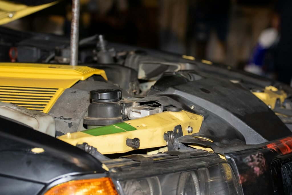 Technician working in a car engine bay, one of many teams using business phone systems for technology services