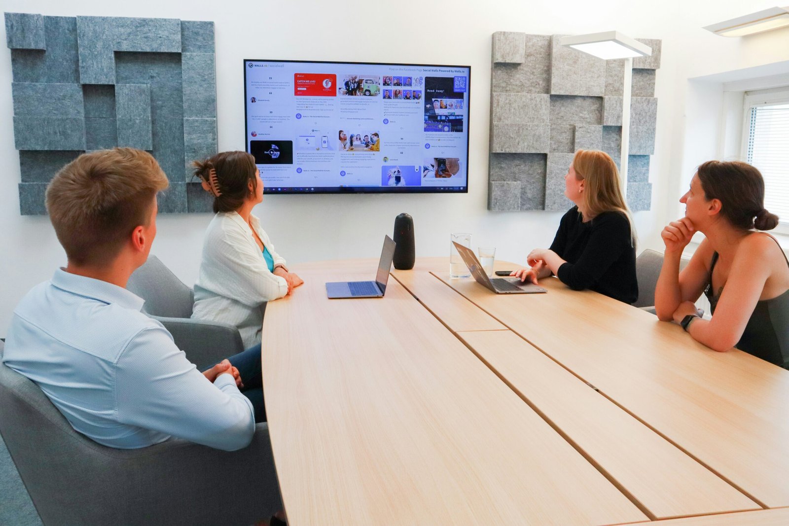 SME Phone Systems Bright meeting room where a team holds a video call with colleagues at another office