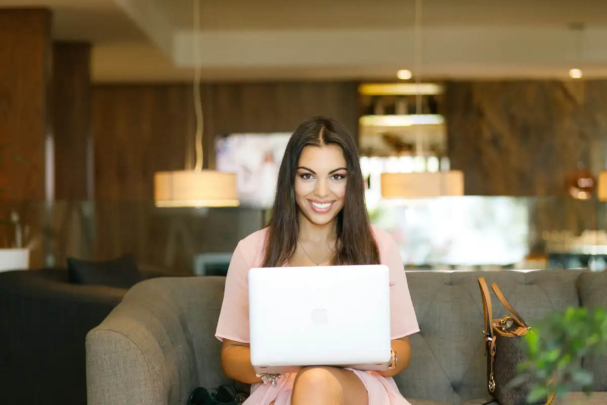 AI-Powered Contact Centre Smiling team member using an AI contact centre tool on a laptop